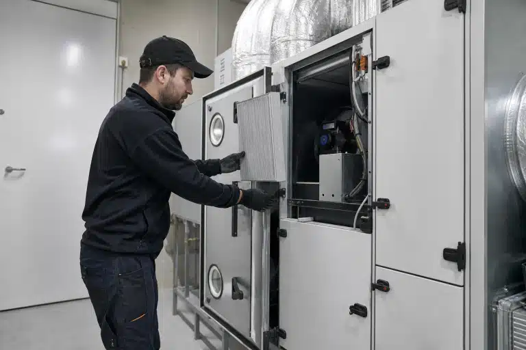 Technicien en gants ouvrant une armoire de traitement d'air